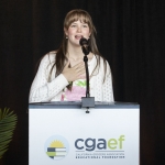 Young girl speaking at podium with hand on her heart.