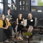 Five people in business attire sit attentively in a modern, stylish lounge setting.